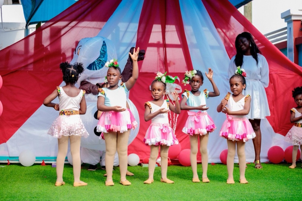 Young dancers in tutus and flower crowns performing on the school lawn